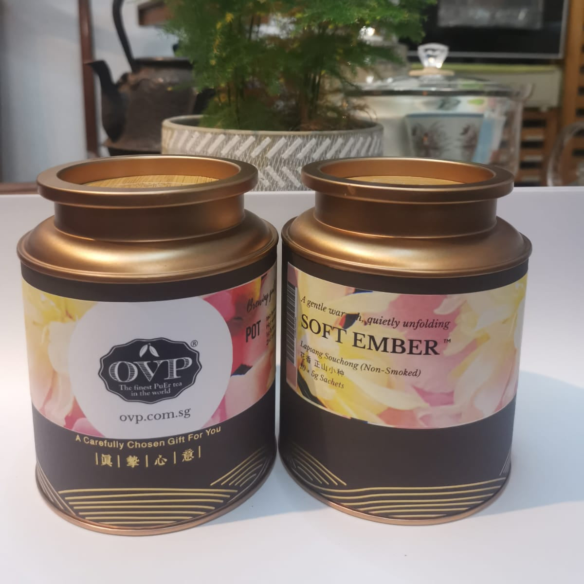 Two tea canisters labeled 'OVP' with decorative labels on a white surface.